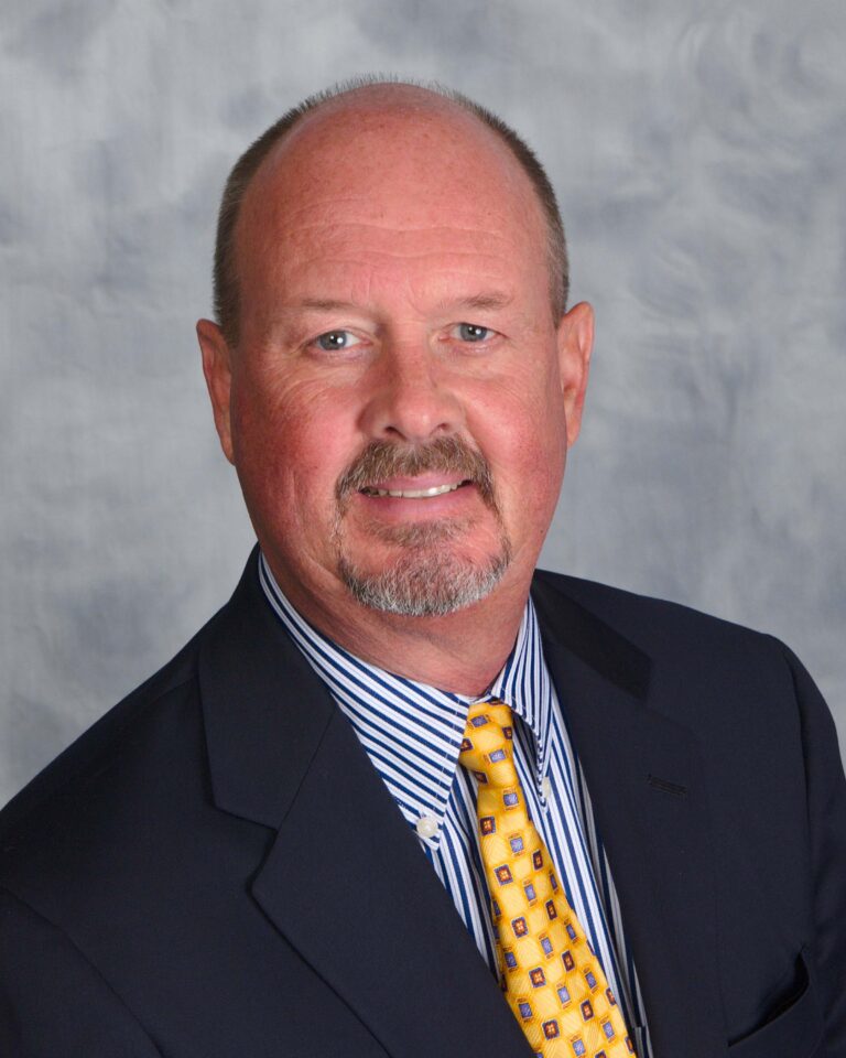 Middle-aged man wearing suit and yellow tie